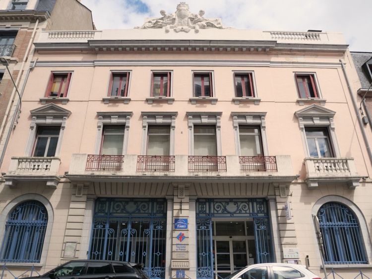 Une vue de la façade de l'Office de Tourisme de Tarbes avec grands portails en fer forgé bleu